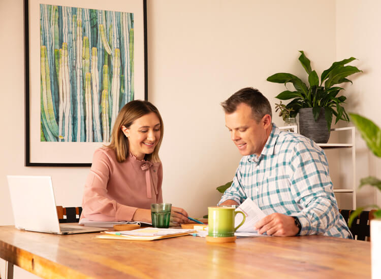 Couple sitting at a dining table reviewing home loan documents together